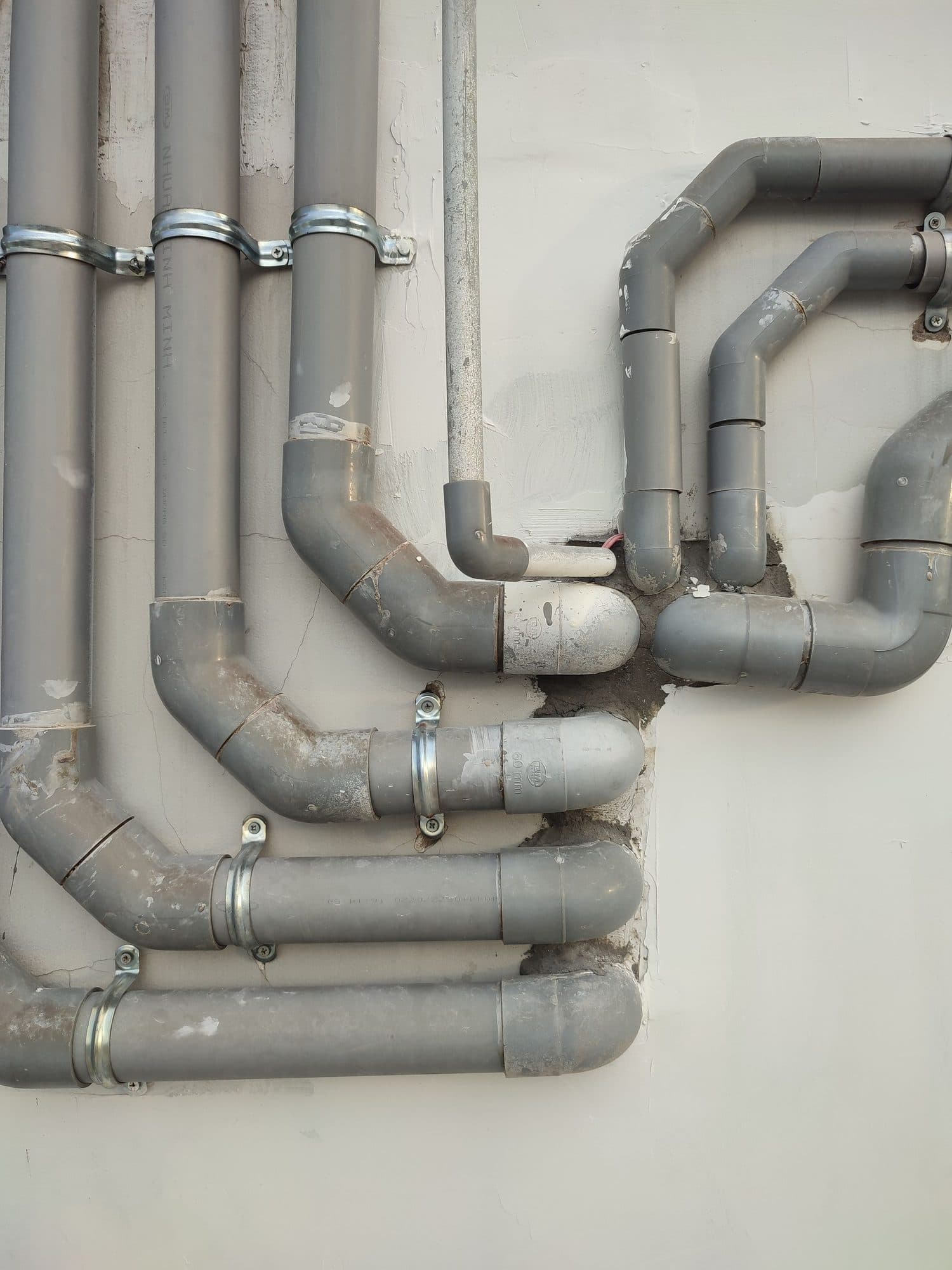 Grey plastic pipework fixed to a wall